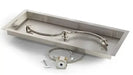 A close-up photo of a rectangular stainless steel gas fire pit burner with an S-shaped design. The burner has small holes drilled along its length.