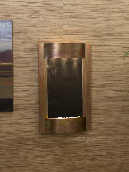 indoor wall fountain hung on passage. copper frame with featherstone backdrop and white pebbles.