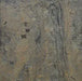 A close-up shot reveals the natural texture of a slate panel. The surface shows variations in color, ranging from dark grey and black to lighter tan and brown hues. Subtle ridges, cracks, and mineral deposits are visible across the stone.