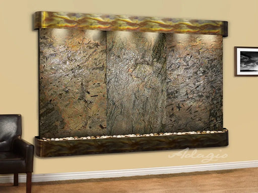 Close-up of an Adagio Solitude River Wall Fountain featuring three natural stone panels, an illuminated copper header, and a basin with river rocks.