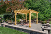 A wooden pergola with a gabled roof, surrounded by a small patio with furniture.