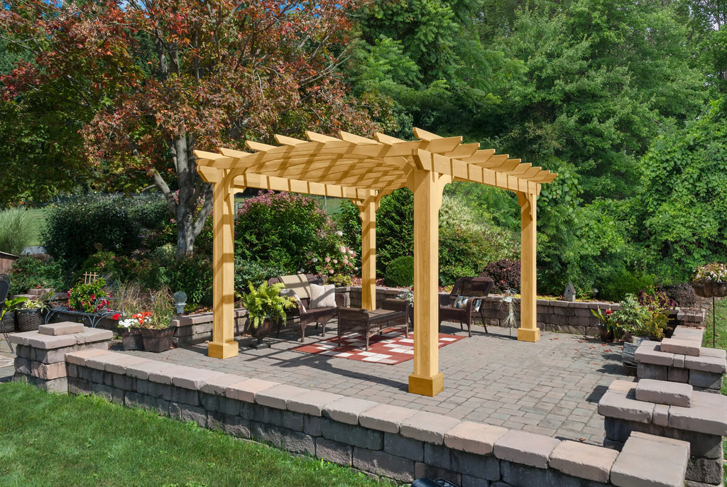 A wooden pergola with a gabled roof, surrounded by a small patio with furniture.