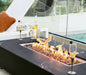 black rectangular fire pit table with two wine glass and wine cooler