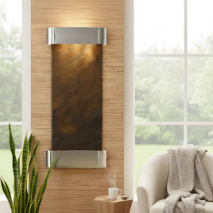 Decorative wall piece with a brown and silver design in a room with a couch and plant.