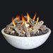 white fire pit bowl with lava rocks and fire logs in the fire pit. fire pit is lit with orange and yellow flames on a black background