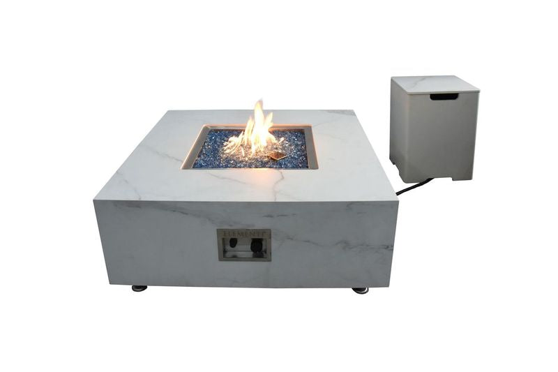 square white marble with black accents fire table that is lit with tank cover beside it