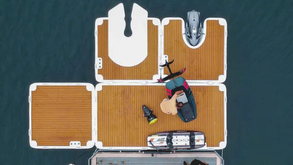 Top-down view of a boat with storage compartments and equipment on a body of water.