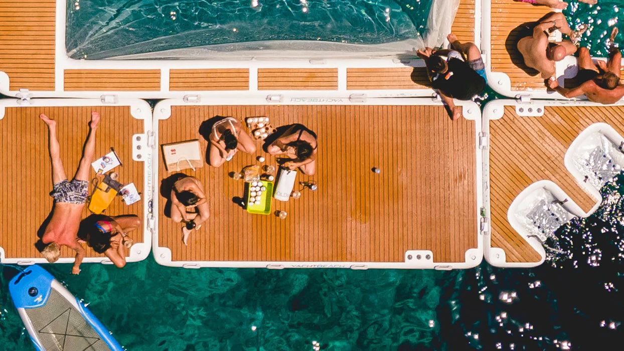 People lounging on a boat with wooden deck and turquoise water
