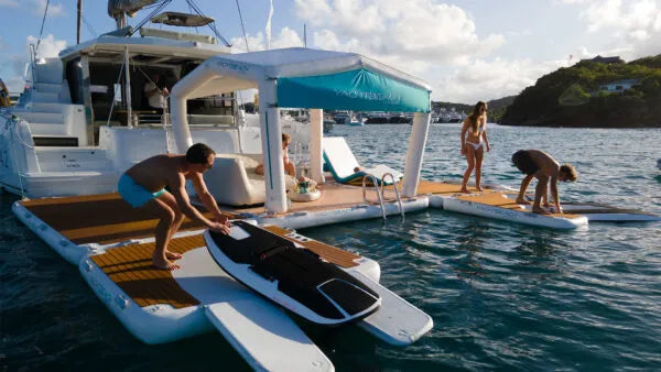 People on a catamaran with a canopy, preparing for water activities.