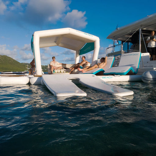 People relaxing on a floating platform with a foil ramp attached on a scenic background