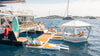 Floating lounge area on a body of water with people enjoying the sun.