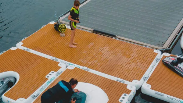Two people on a large floating dock with water in the background