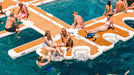 People relaxing on a large inflatable pool float in a pool.