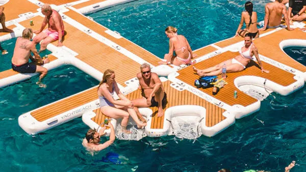 People relaxing on a large inflatable pool float in a pool.