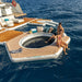 Two people on a floating yacht platform in the ocean with 'Yachtbeach' branding.