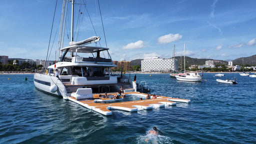 A yacht with a YACHTBEACH platform and pool in the water