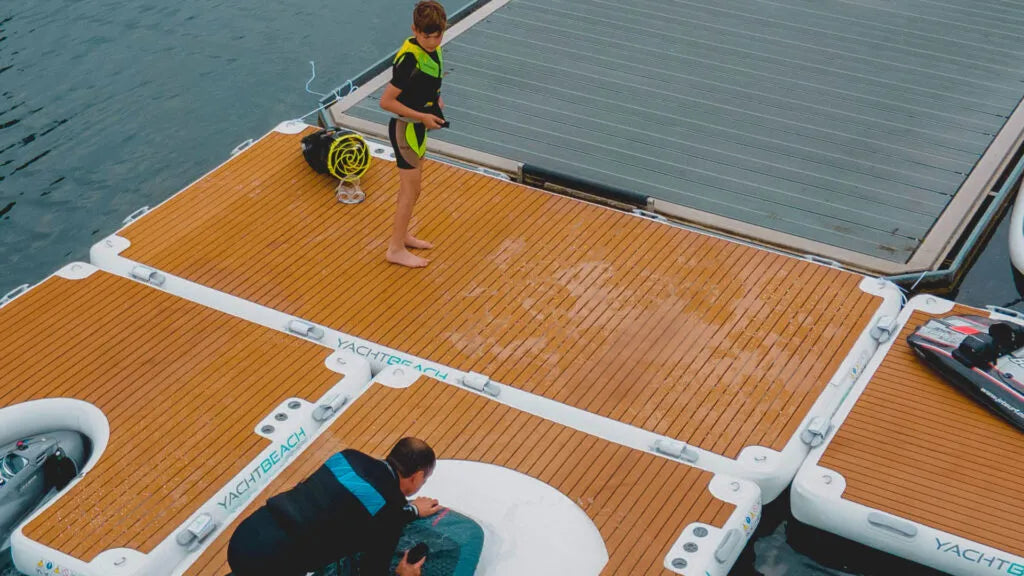 Two people on a floating dock with 'Yacht Club' branding.